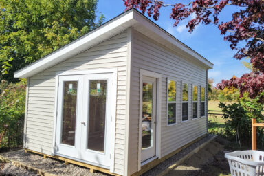 white vinyl studio shed with large windows